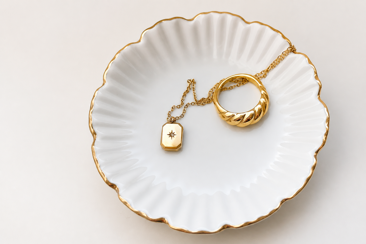 A ring and necklace resting on a porcelain dish, an illustrative jewelry-care photograph.