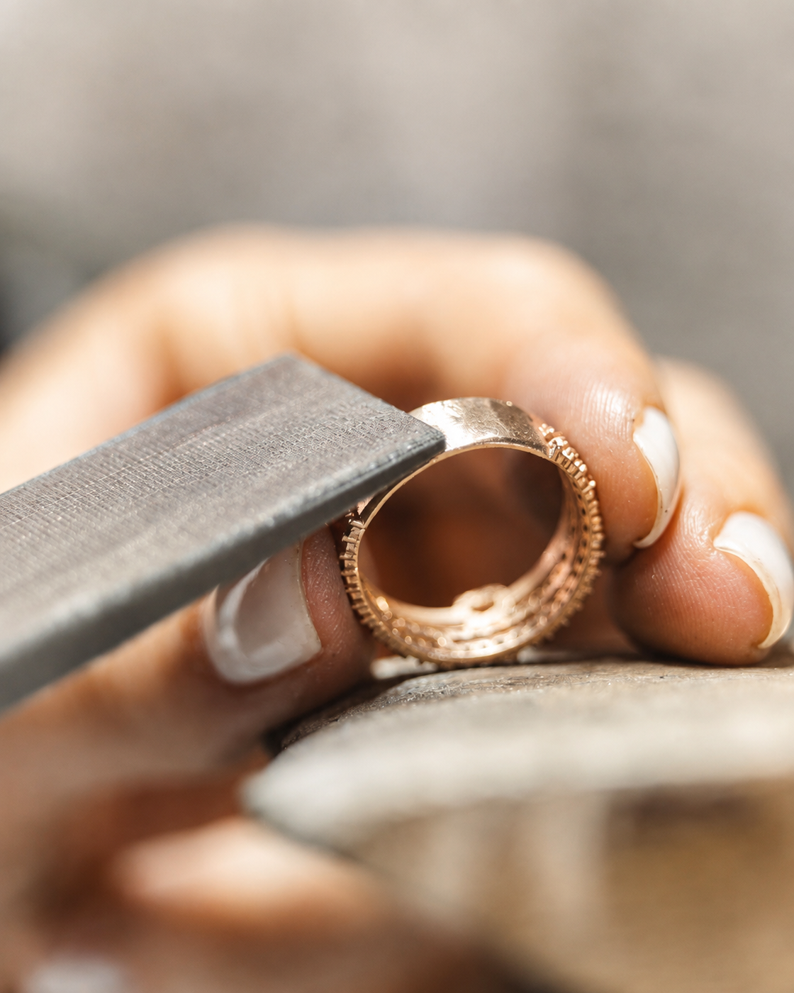 Close-up editorial study of a hand filing a ring