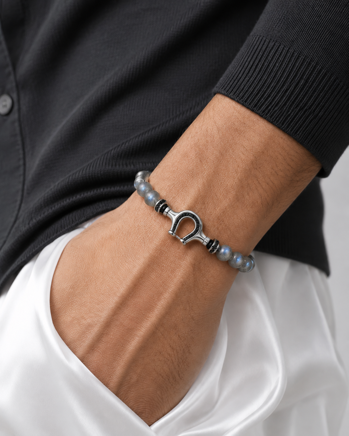 VESPERON beaded horseshoe bracelet worn with charcoal and white clothing; editorial retouch.